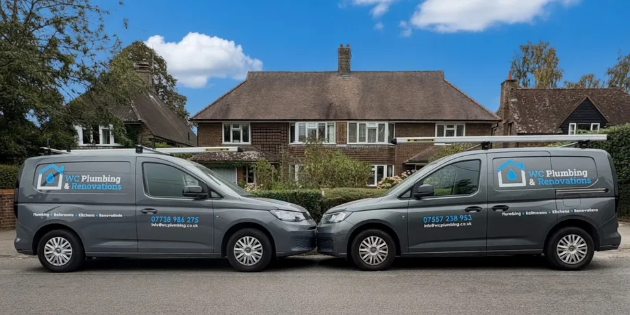 Two WC Plumbing and Renovations vans outside a residential property