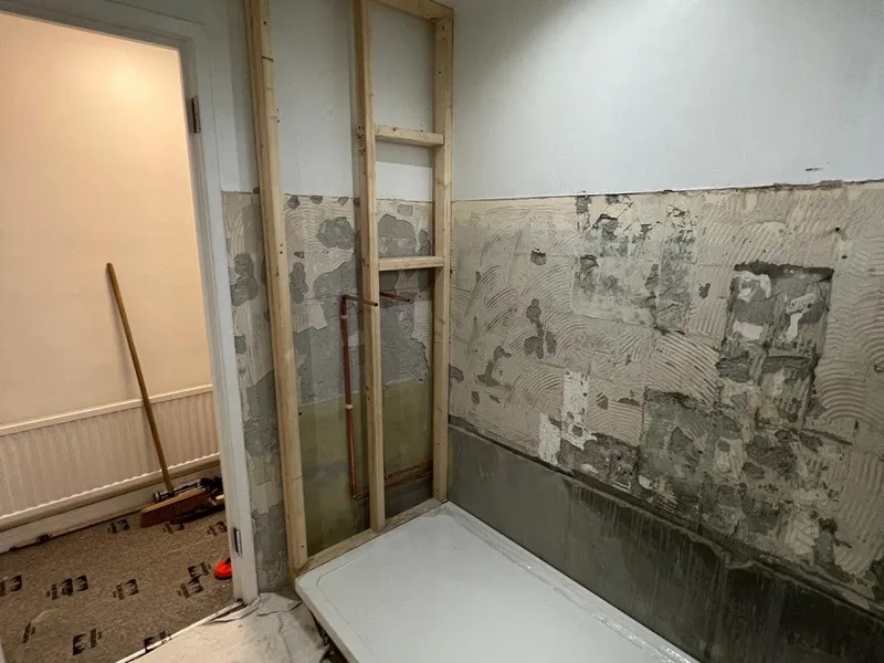 Bathroom renovation work in progress with exposed walls and first-fix plumbing